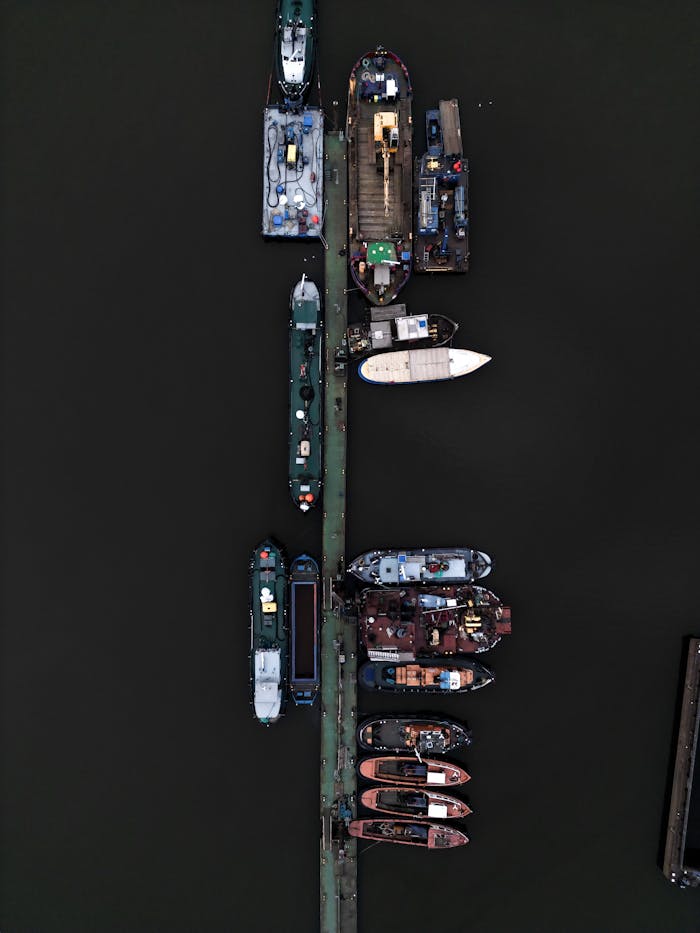 Aerial view of various boats moored in Hamburg harbor, showcasing a bustling maritime scene.